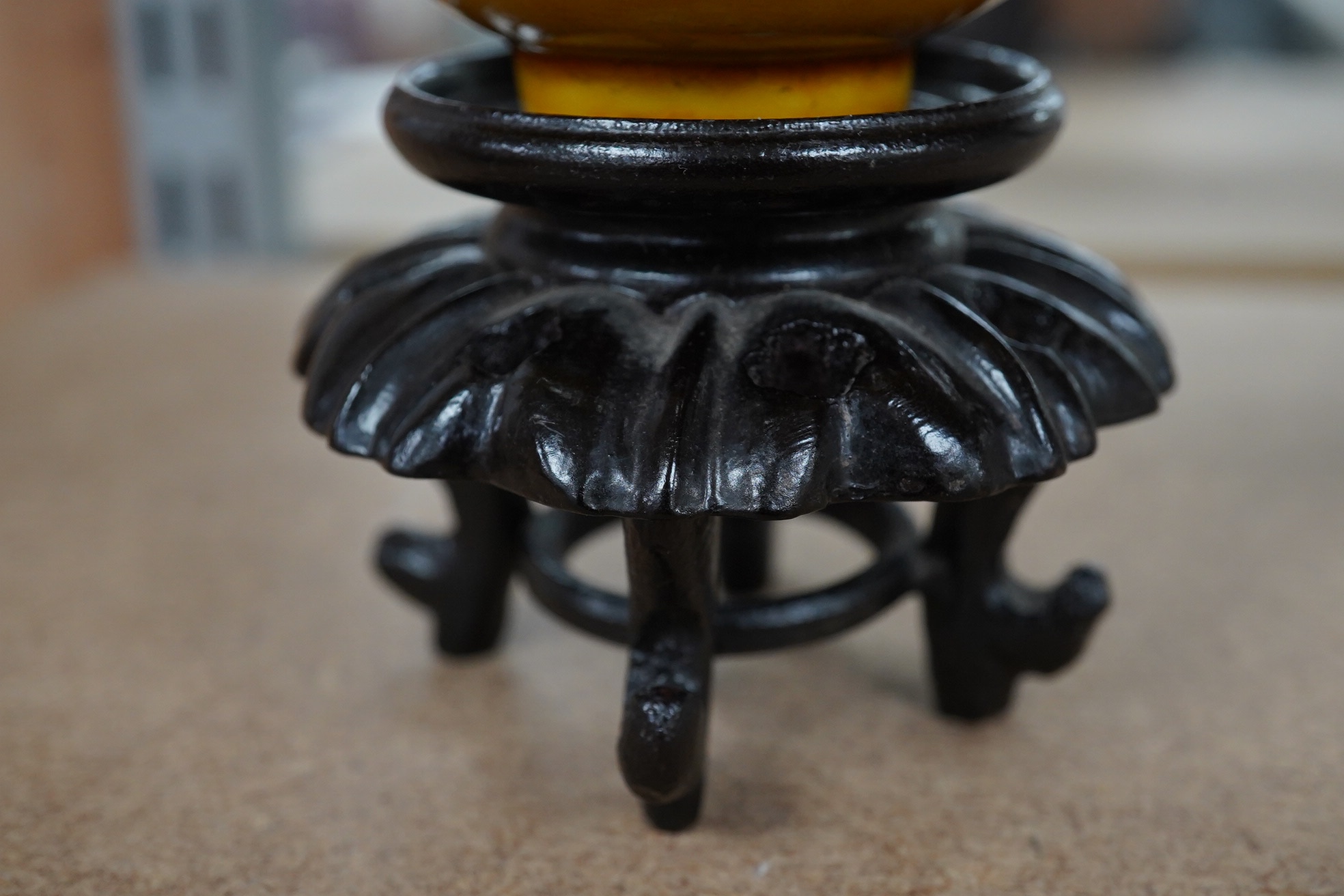 A Chinese yellow glazed teabowl on hardwood stand, 9cm diameter. Condition - fair